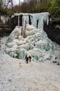 Hikers at the base of Frozen Cascade Falls Royalty Free Stock Photo